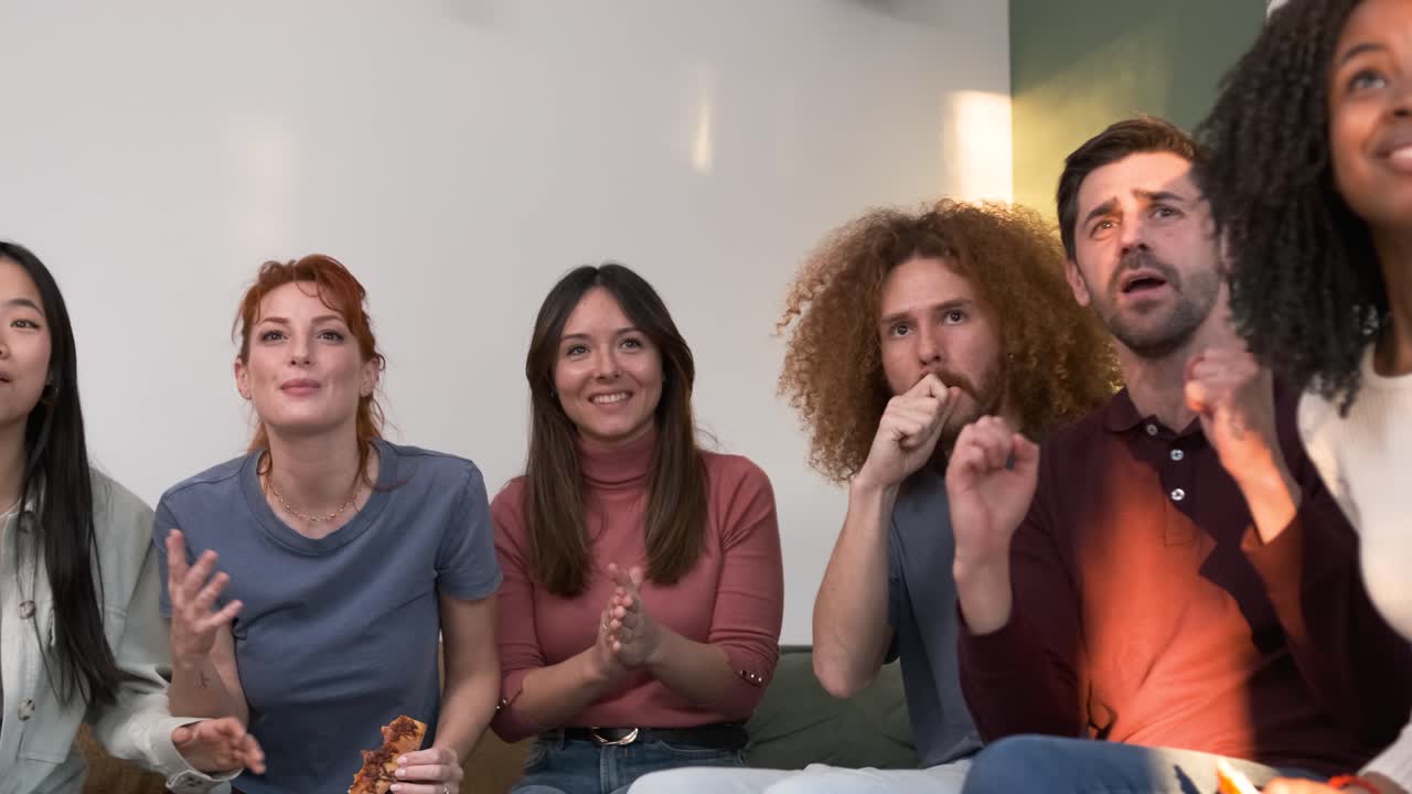 Cheerful friends rejoicing over victory while watching TV