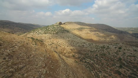 arid hilly landscape under partly cloudy sky
