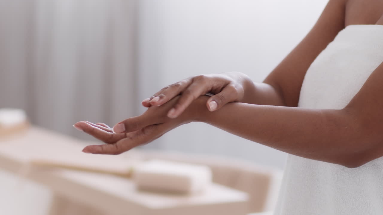 Kvinde påfører lotion på sine hænder og arme