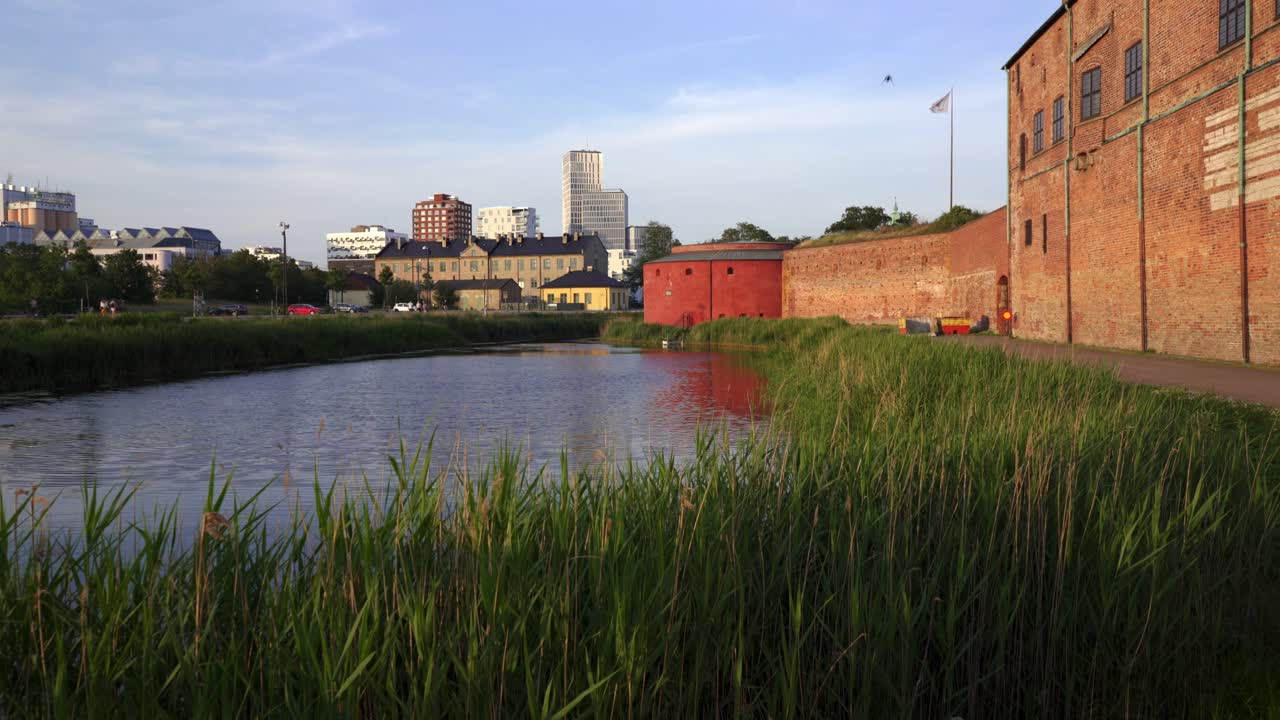 Vista del Castello di Malmö che conduce allo skyline moderno attraverso il fossato storico