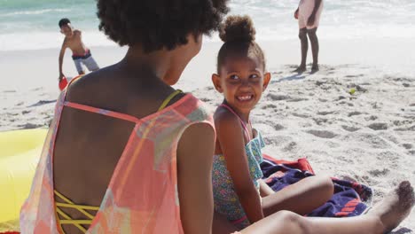 Smiling-african-american-family-using-sun-cream-on-sunny-beach