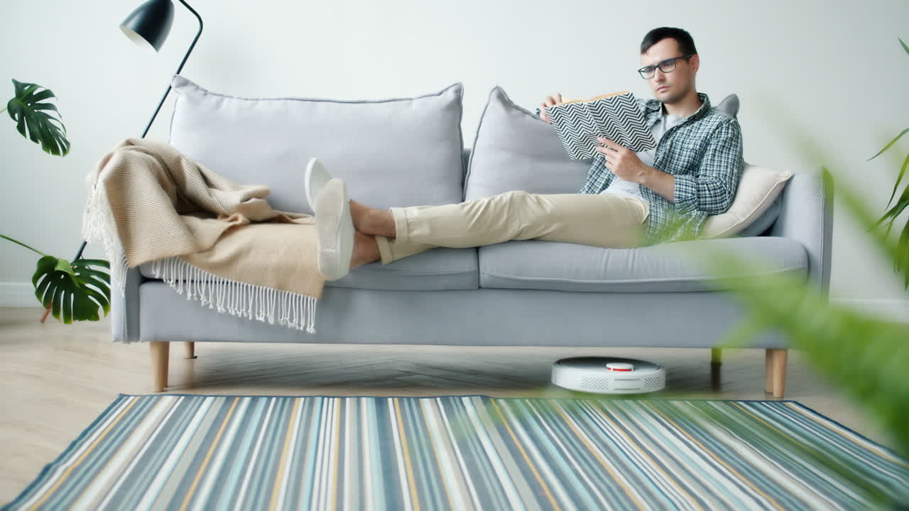 Man Relaxing on Couch Reading a Book