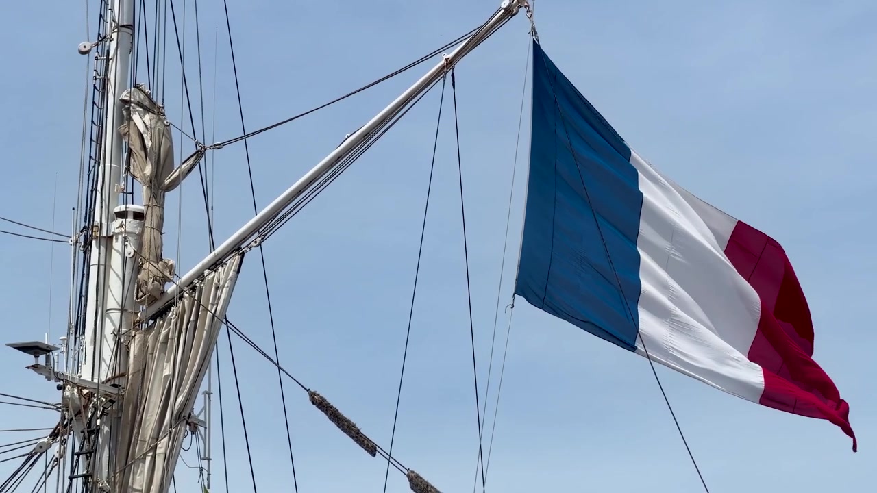 Frankrigs nationalflag blafrer fra riggen på en sejlbåd i Marseilles havn.