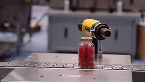 bottled red gummy supplements on conveyor belt - multivitamin manufacturing