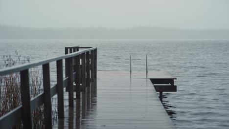 empty pier by the lake on a cold and rainy day