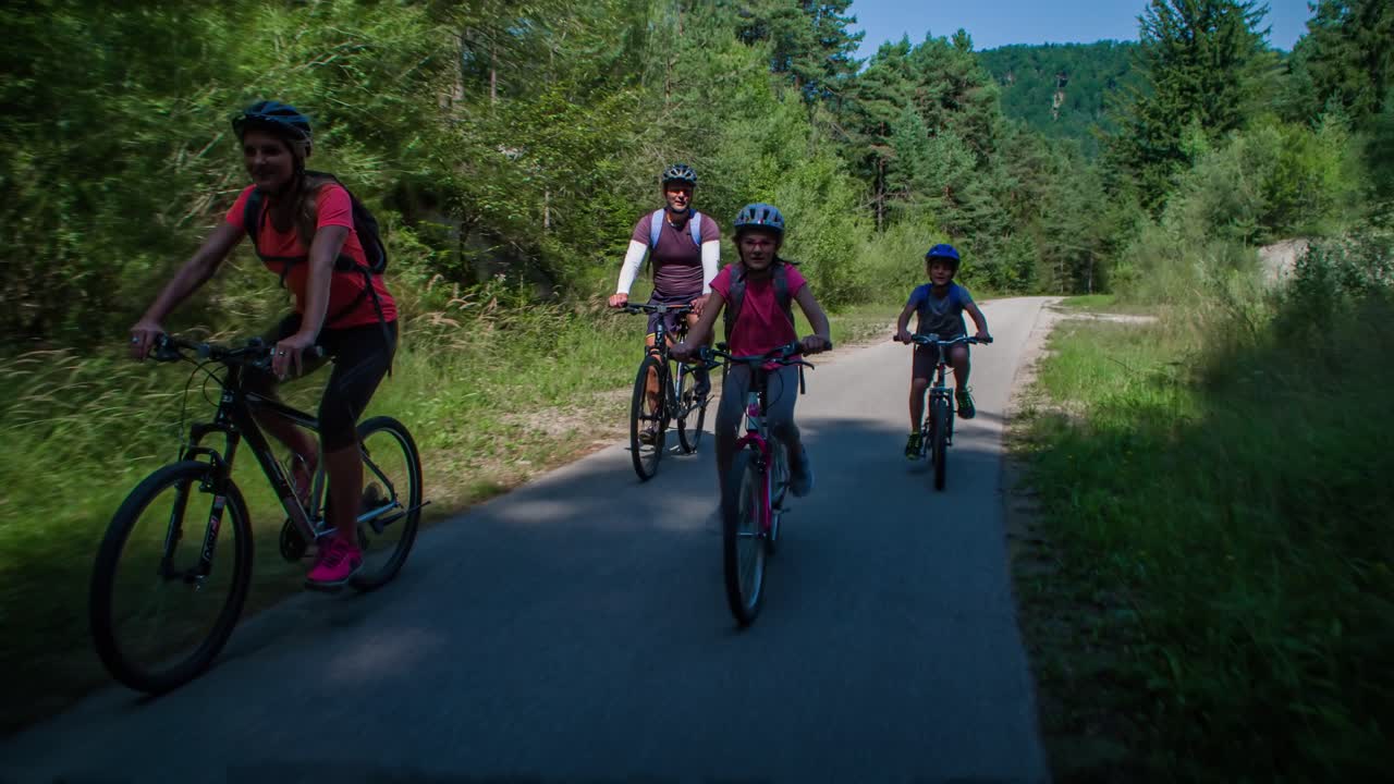 Familia caucásica feliz andando en bicicleta por un sendero en Eslovenia, seguimiento en tiempo real.