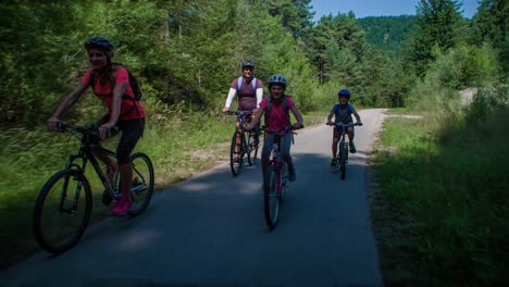 happy caucasian family cycling in trail path slovenia, tracking real-time