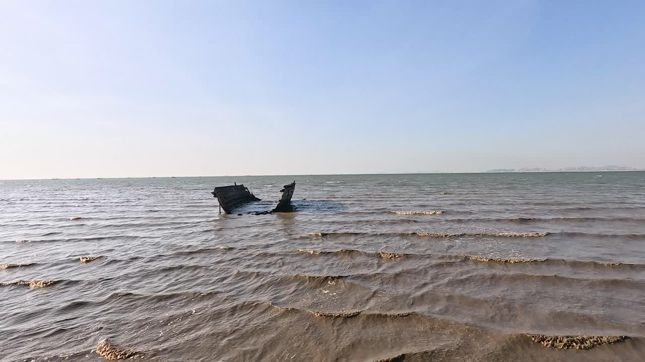 파도가 부드럽게 배 잔해 주변을 움직입니다.