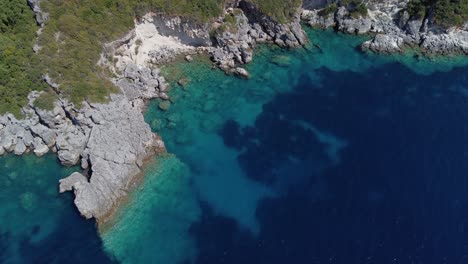 aerial: rocky shore with forest and blue sea water at lefkada, greece: drone flying shot