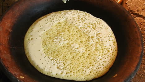 food shot of some homemade traditional moroccan baghrer in clay fryer , pancakes baghrir or crapes with 1000 holes