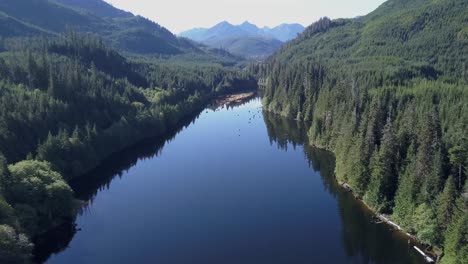 Fly-over-deep-blue-lake-in-rugged-mountainous-terrain