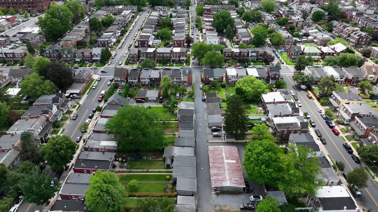 Aerial flyover american city with semi detached houses and row of homes. Sunny day with green trees in spring. Lancaster, Pennsylvania, USA. Wide shot,.