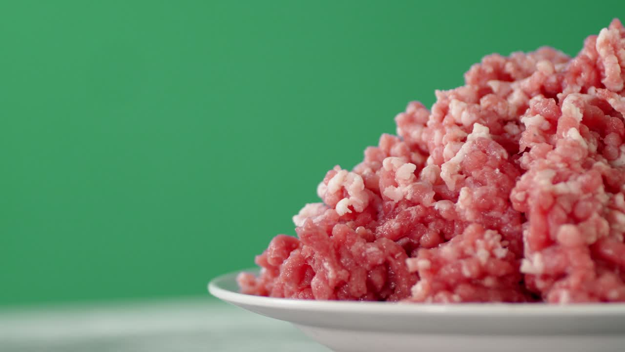 A full plate of raw minced meat rotates.