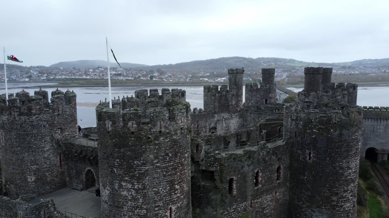 флаги на историческом замке конви вид с воздуха достопримечательность города руины каменная стена крепостные стены туристическая достопримечательность орбита правый кадр