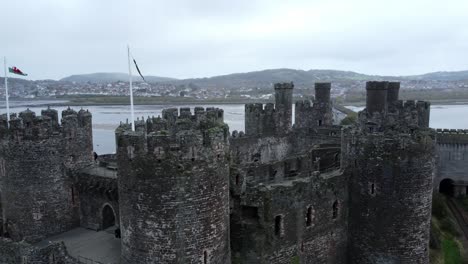 banderas en el histórico castillo de conwy vista aérea de la ciudad histórica ruina muro de piedra almenas atracción turística órbita tiro derecho