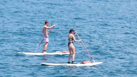 two people paddle boarding in naples, italy