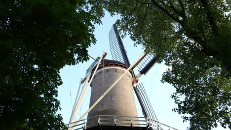 mill t slot against blue sky in gouda, the netherlands - low angle