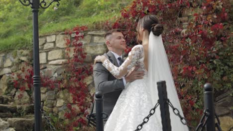 Lovely-newlyweds-caucasian-bride-embracing-groom-in-park-making-kiss,-wedding-couple-family-hugging