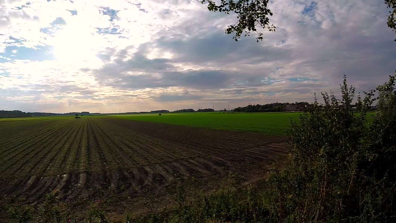 Gepflügte Felder unter bewölktem Himmel in der niederländischen Polderlandschaft
