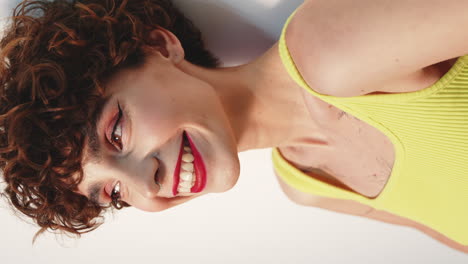 woman with curly hair and a yellow top