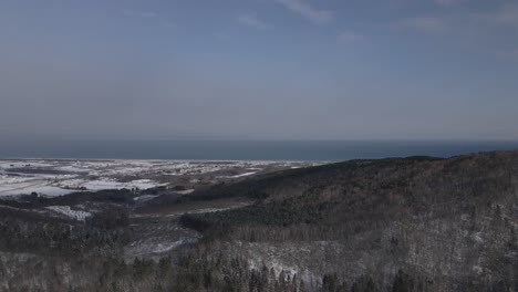 Drohnenschuss,-Der-Im-Winter,-Japan,-über-Einen-Berg-Mit-Meerblick-Fliegt