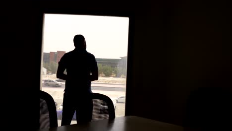 a thoughtful man gazes out the office window, deep in reflection. ideal for corporate, professional life, and business-oriented creative projects