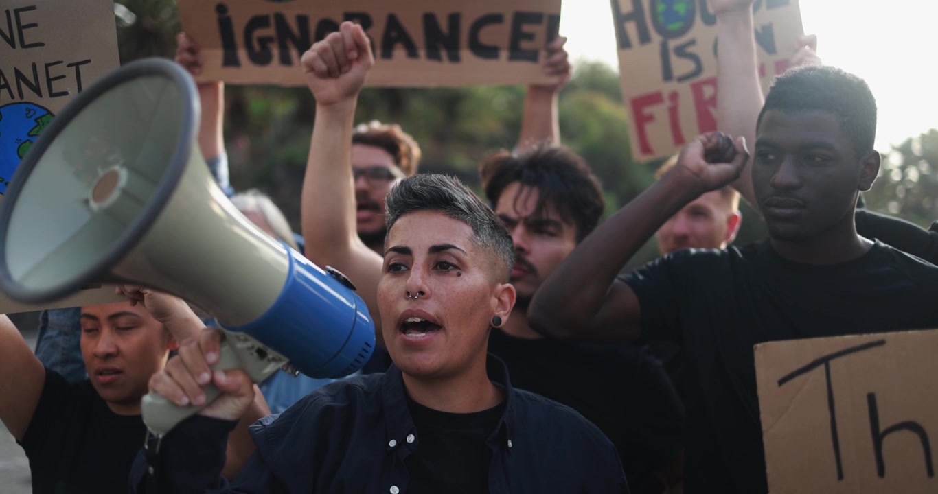 Giovane attivista che parla nel megafono a una protesta diversificata