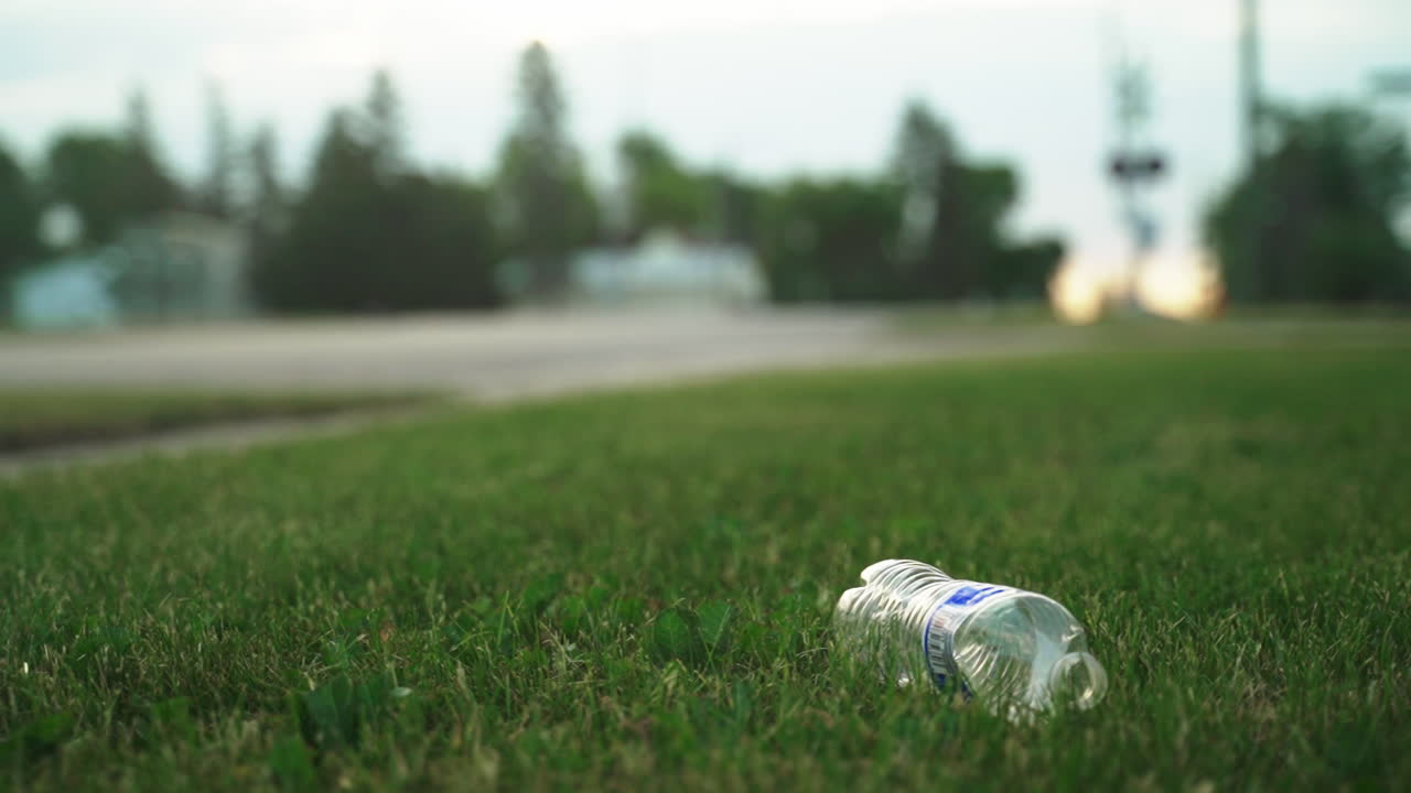 Discarded Plastic Bottle on Grass Field: A Symbol of Environmental Pollution