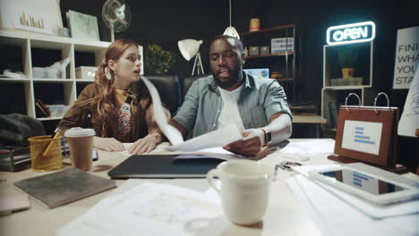 Young mixed race couple emotionally discussing job results in hipster office