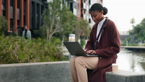 mujer trabajando en una computadora portátil en el parque de la ciudad