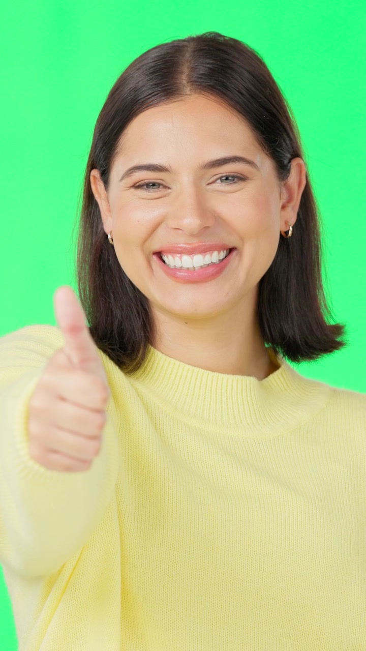 Mujer joven sonriendo haciendo un gesto de pulgar hacia arriba