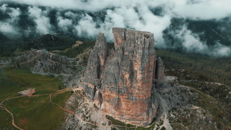 soft clouds enveloping cinque torri rock formation, revealing dramatic mountain landscape nestled within italian dolomites' rugged alpine terrain