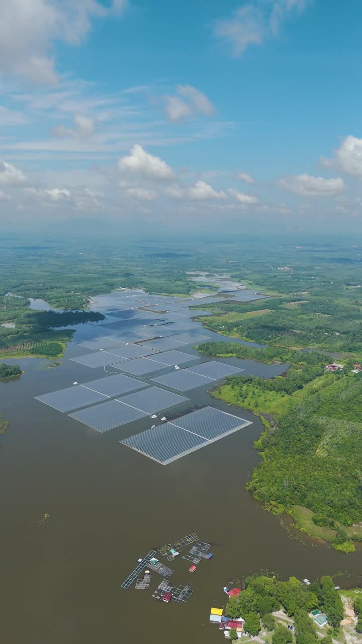 Vertical aerial view of Danau Tok Uban in Kelantan, Malaysia, showcasing the nation’s largest floating solar farm set across the serene lake, surrounded by lush greenery and rural landscapes