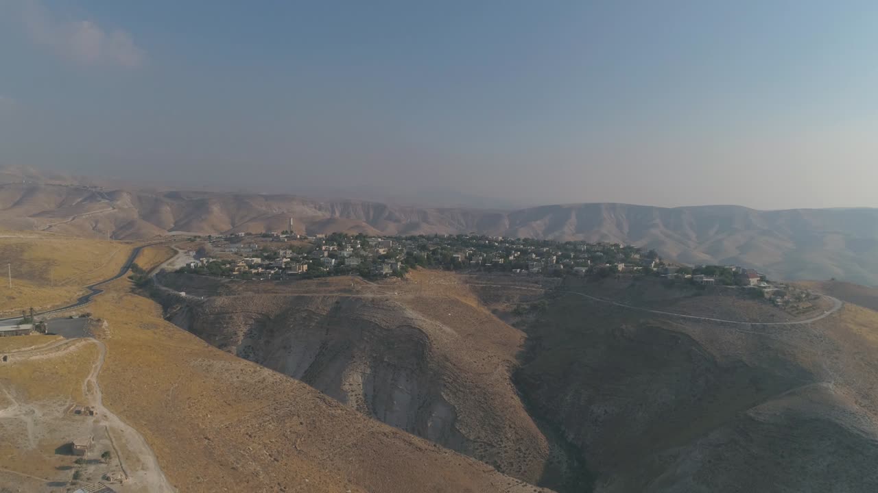 Insediamento ebraico nel deserto della Giudea e della Samaria in Israele. Vista aerea con drone di case di villaggio su cime di montagne. Vita mediterranea all'aperto in coesistenza.