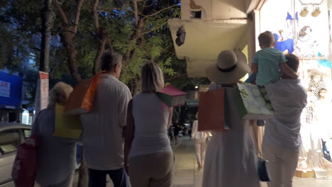 big family walking in night street after shopping