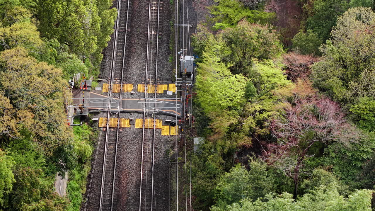 Aerial drone view of a train moving through the Arashiyama train station, Kyoto, Japan in daylight