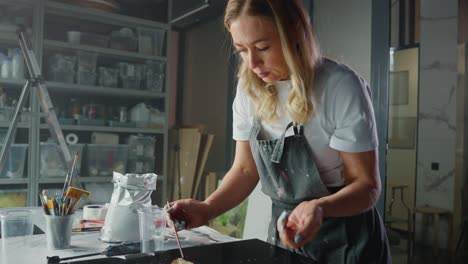 woman artist working on resin art project in studio