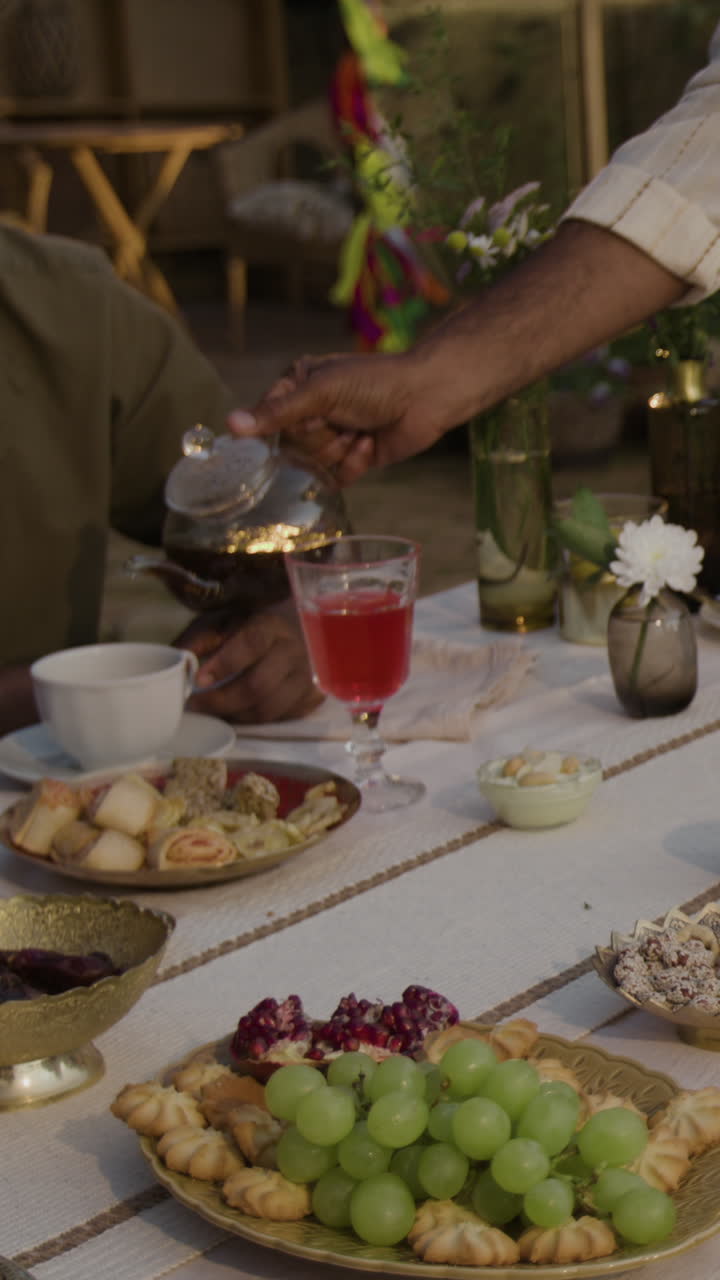 People enjoying tea and a variety of snacks at an outdoor gathering