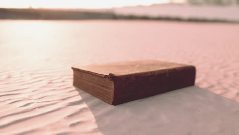 old book in the desert at sunrise/sunset