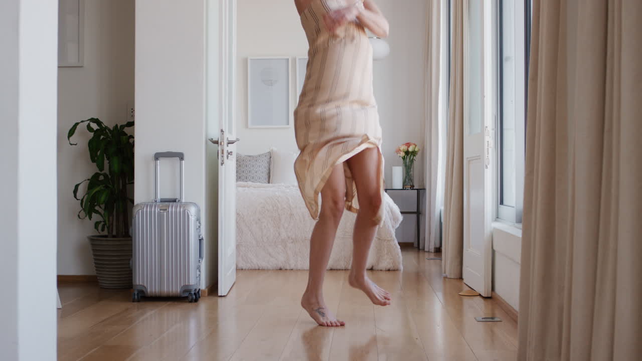 donna felice che salta sul letto in una stanza d'albergo che si diverte a godersi le vacanze stile di vita che celebra la libertà