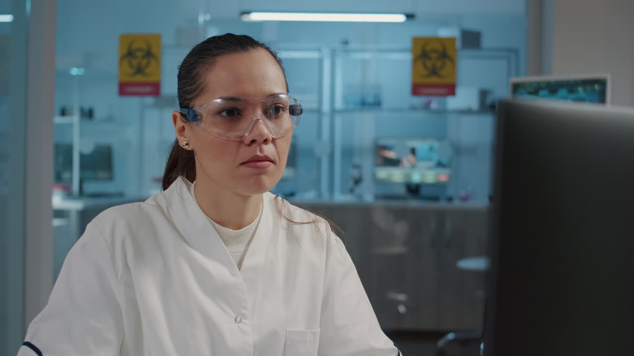 Woman chemist working on computer in science laboratory
