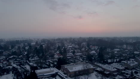 High-jib-up-of-small-town-covered-in-snow-at-dawn