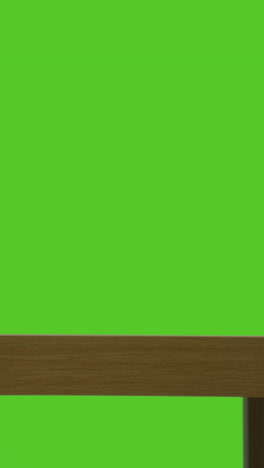 vertical video of man picking up and putting down present in gift wrapped box from table shot against green screen