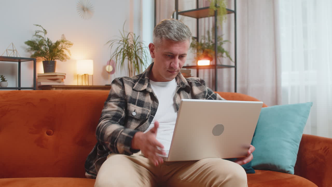 Displeased man use laptop surprised by bad news virus error game fail lottery results at home