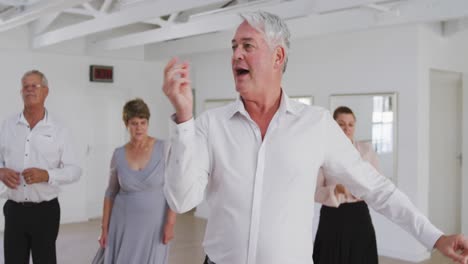 pareja de adultos mayores caucásicos pasando tiempo juntos bailando en un salón de baile