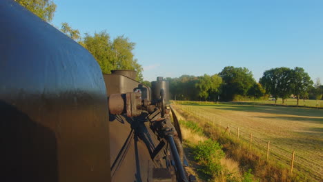 moving steam locomotive blows on steam whistle