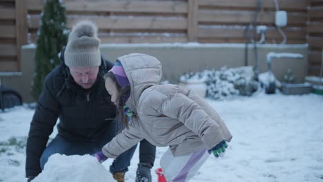 grandfather and granddaughter having fun in the snow