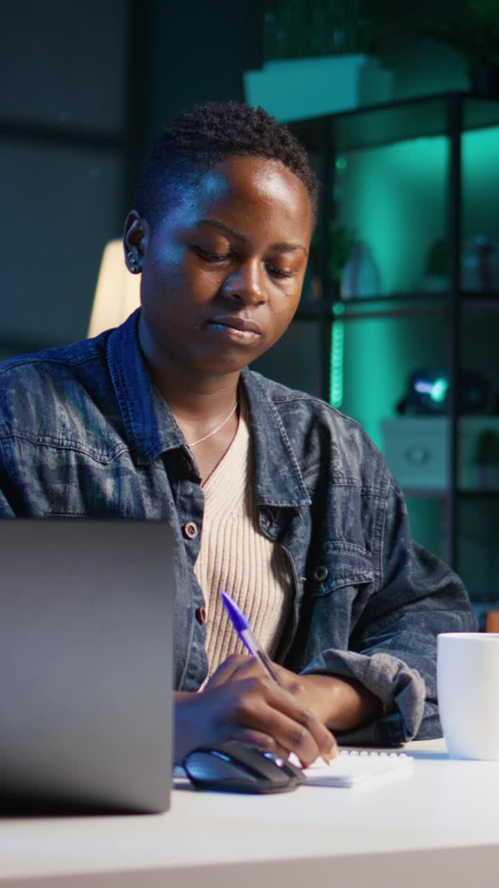 Vertical video Freelancer noting down ideas on paper using pen while teleworking