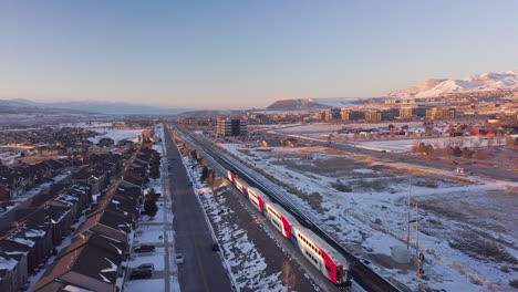 a commuter train runs through a suburban and business area - aerial view