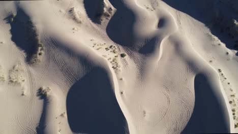 Revealing-aerial-of-Salamayuca-Desert,-a-striking-natural-wonder-nestled-along-the-Mexican-US-border-near-Ciudad-Juarez,-desolate-landscape-with-low-angle-sunlight